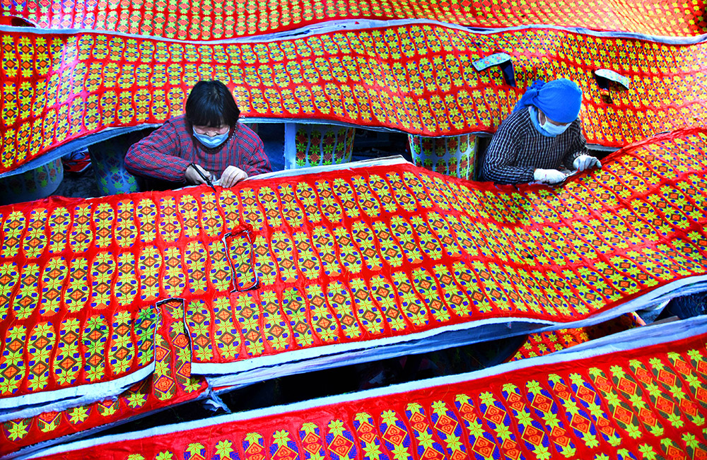 山东省沂源县石桥镇石龙官庄村的农家妇女在加工鞋垫（3月2日摄）。