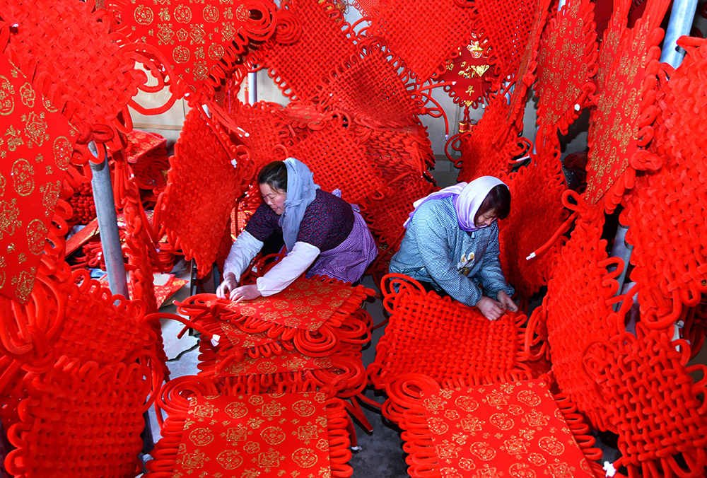 山东省沂源县历山街道东鱼台村的农家妇女在加工中国结（3月6日摄）。