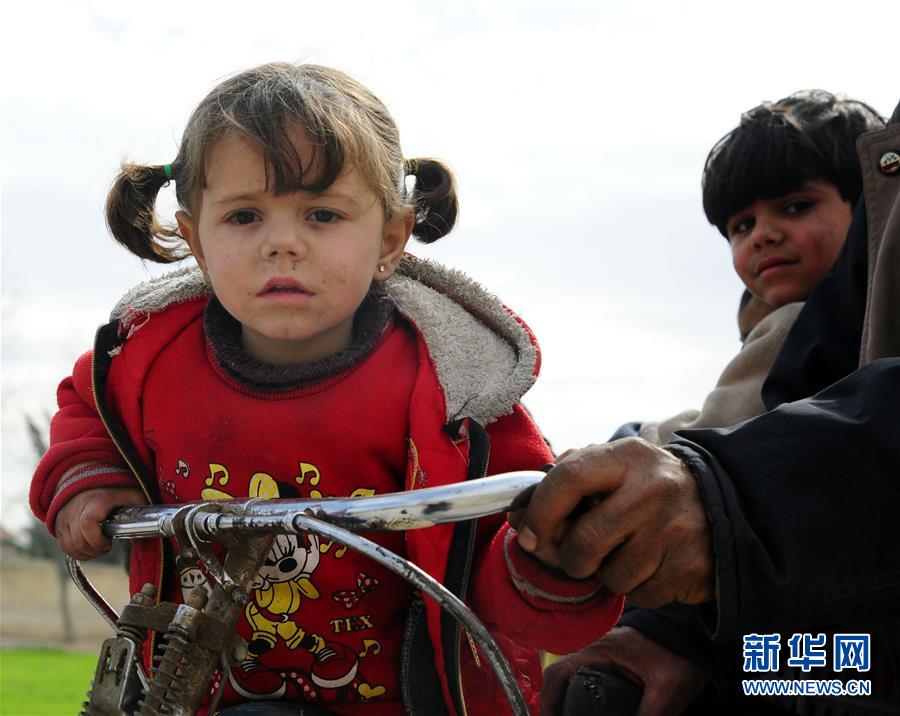 3月15日，在叙利亚大马士革东郊，一名女孩坐在自行车上随家人撤离。