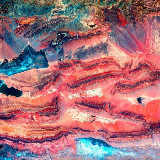 位于新疆天山以南的柯坪山冲断带。图片中明亮的颜色表明岩层中的断层是在不同时期、不同的气候条件下形成的。