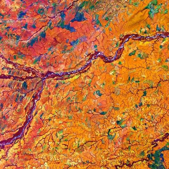 热带草原中的梅塔河，拍摄于哥伦比亚和委内瑞拉的边界地区。梅塔河（中部）两岸覆盖着厚厚的乔木植被，将橘色的热带草原一分为二。