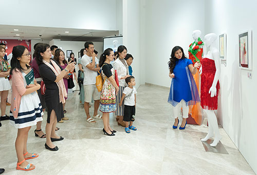 策展人杨贝贝向嘉宾介绍新加坡中国文化中心“时代映像——中国时装艺术精品展”展览作品