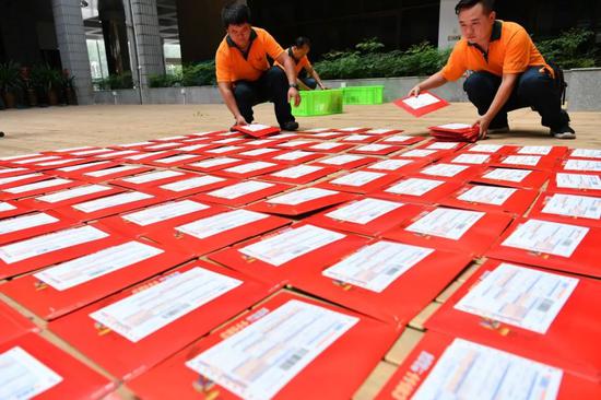 △2017年7月25日，云南邮政工作人员把录取通知书逐一装箱带走。/视觉中国