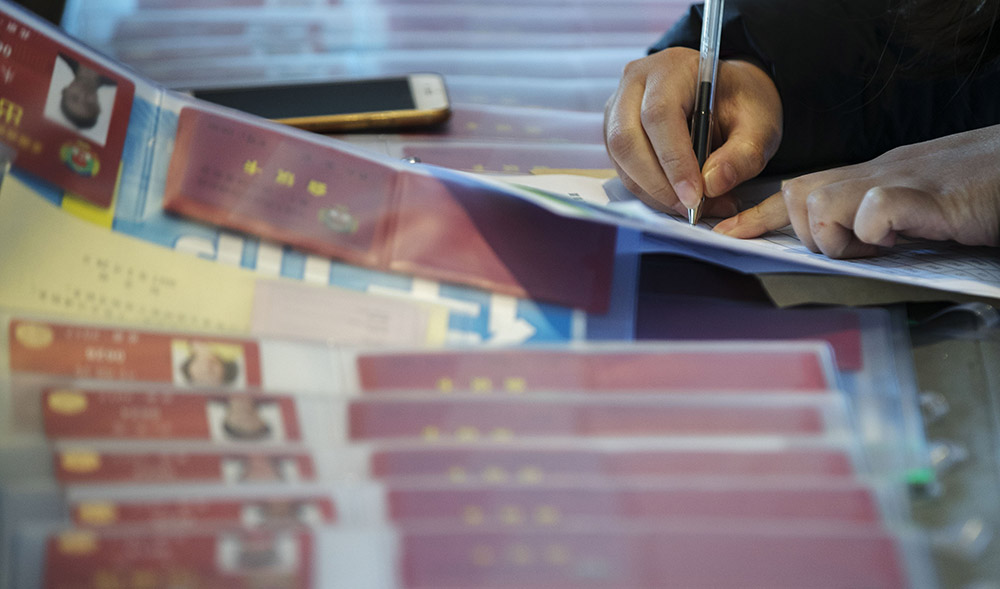 3月1日，一位抵达驻地北京昆泰酒店的政协委员在填写表格。