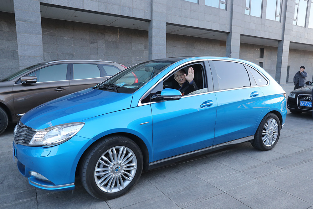 3月1日，全国政协委员黄力在驻地北京会议中心报到后，驾驶纯电动汽车离开。
