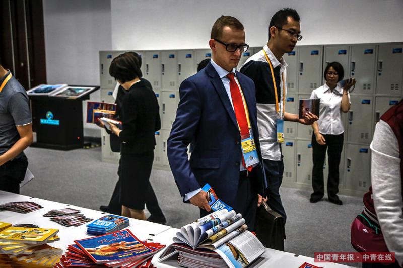 一名外国记者取走一份《北京地图》。《北京指南》《北京地图》等书籍出现在许多外国记者的手中。