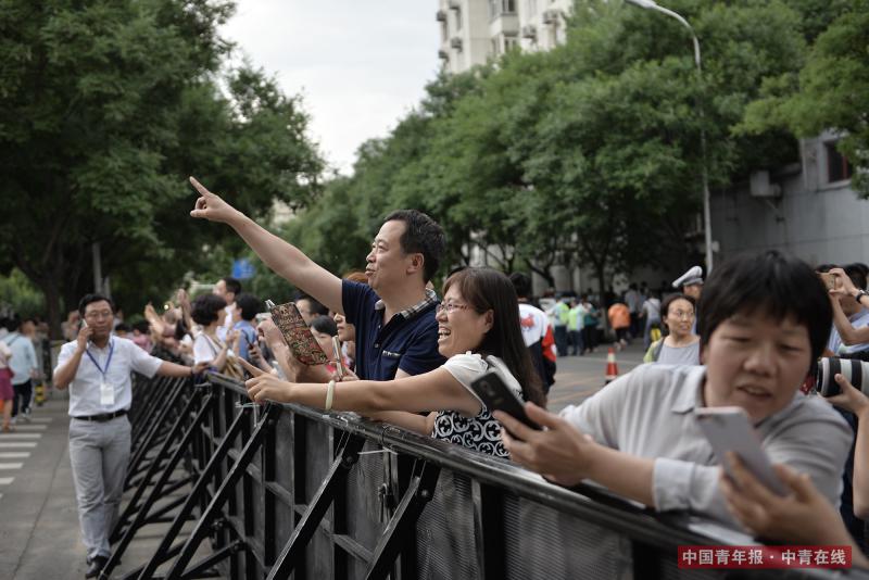 6月8日下午，北京东直门中学高考考点外，高考结束后，一对家长看到孩子走出考场，指示要为其拍照留念。中国青年报·中青在线记者 王婷舒/摄