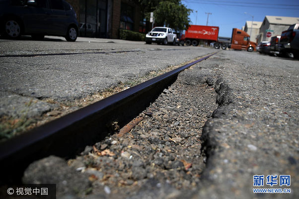 当地时间2017年7月12日，美国加州奥克兰，据报道，旧金山、奥克兰和其他四座加州城市的道路是全美道路状况最差的城市，司机因为坑洼不平等道路问题，每年平均花费978美元修车。***_***OAKLAND, CA - JULY 12: A large pothole is visible on 20th Street on July 12, 2017 in Oakland, California. According to a report by WalletHub, roads in San Francisco, Oakland and four other California cities are the worst in the United States. Drivers in San Francisco and Oakland pay an estimated $978 per year to repair vehicle damage from driving on roads with potholes and uneven pavement. (Photo by Justin Sullivan/Getty Images)