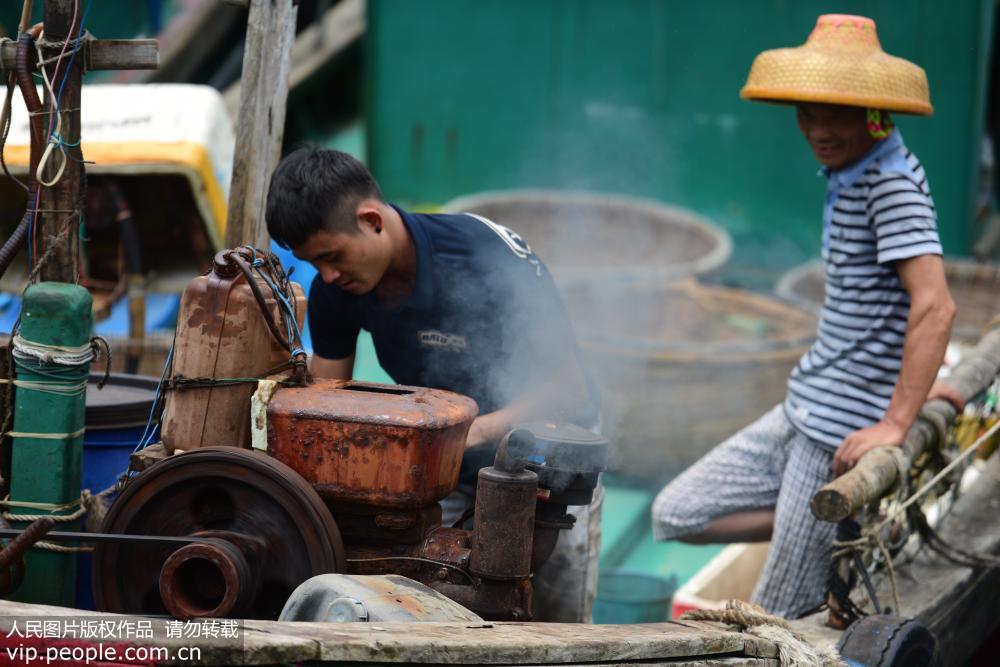 8月16日，海南省琼海市潭门港，渔民发动机器准备出海。