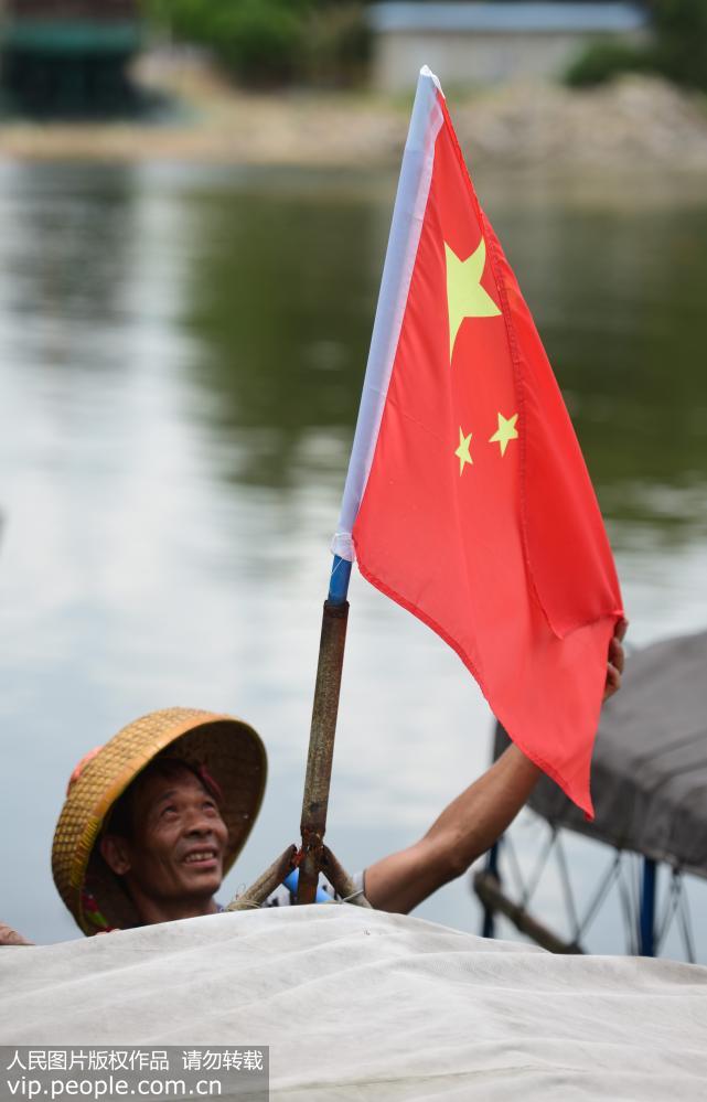 8月16日，海南省琼海市潭门港，渔民悬挂国旗准备起航。
