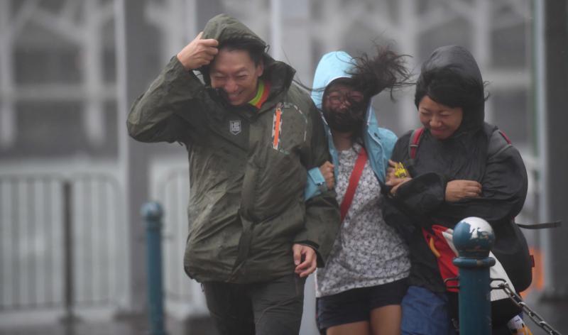 8月23日，香港，游客在风雨中前行。当日，受台风“天鸽”影响，香港天文台于上午挂出10号风球，为5年来首次。新华社记者 吕小炜摄