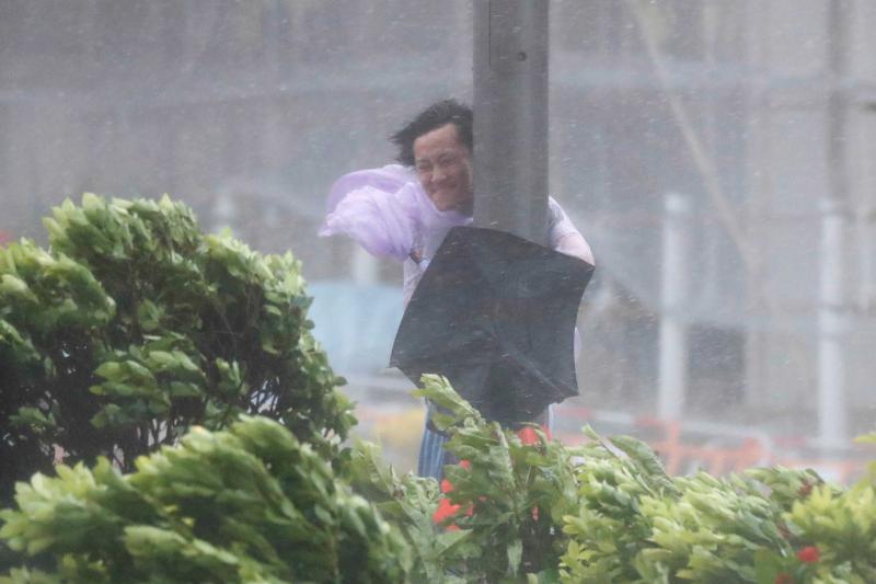 8月23日，香港， 一位路人在暴风雨中紧抱电线杆。香港天文台在今天上午8点10分发出九号烈风或暴风风力增强信号。来自中央气象台的消息显示，第13号台风“天鸽”（强台风级）的中心已于23日中午前后在广东珠海南部沿海登陆，登陆时中心附近最大风力有14级。中国气象局专家称这是今年以来登陆我国的最强台风。视觉中国