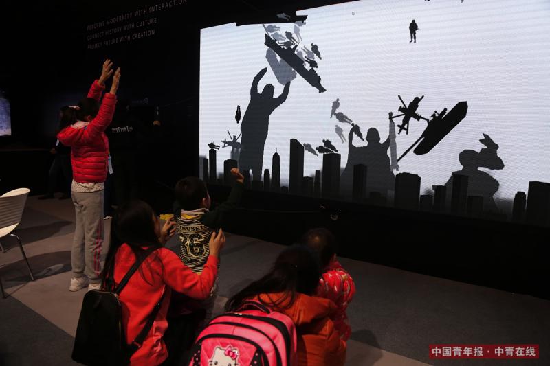 12月9日，孩子和家长体验军事题材的交互设备。中国青年报·中青在线记者 赵迪/摄