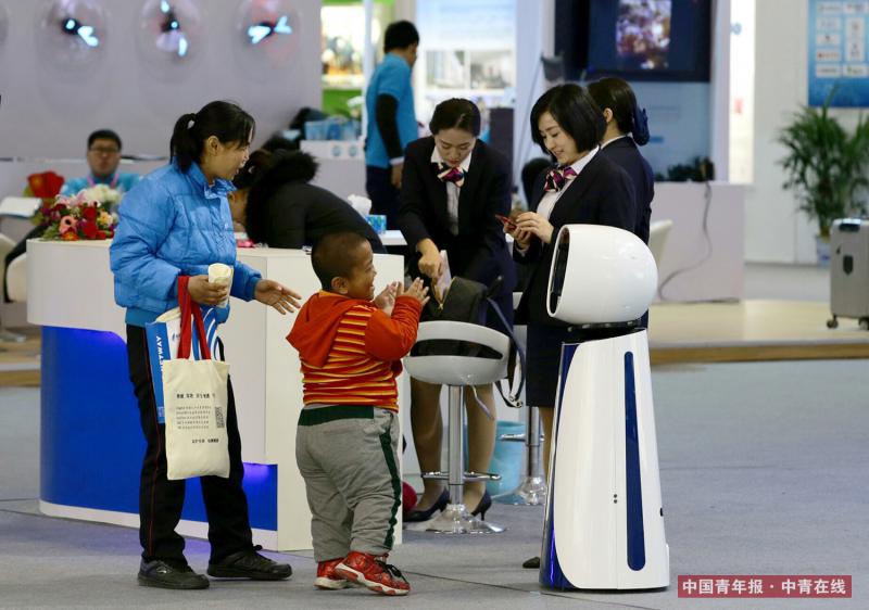 12月9日，江苏银行展台，参观者被一个服务机器人吸引。中国青年报·中青在线记者 陈剑/摄