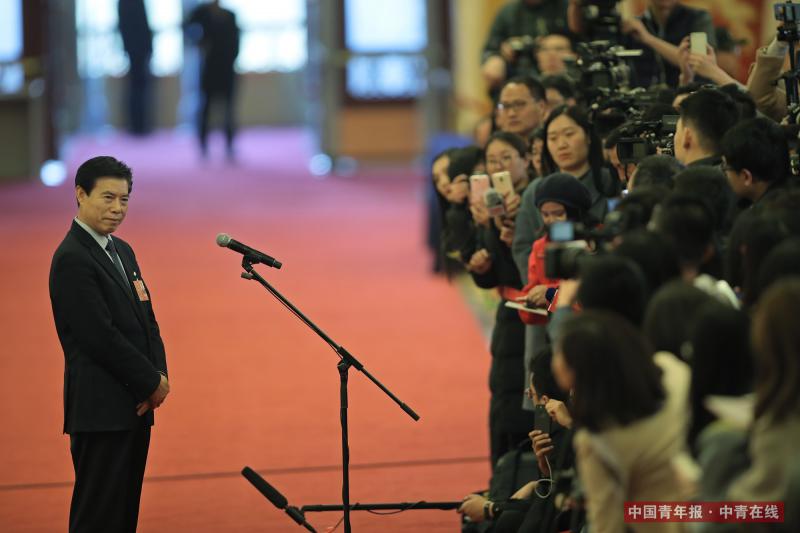 3月5日，十三届全国人大一次会议开幕会结束后，商务部部长钟山在经过人民大会堂“部长通道”时表示，中国去年成为世界第一贸易大国，贸易大国地位更加巩固。中国青年报·中青在线记者 赵青/摄