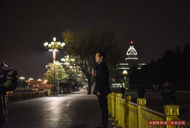 3月11日晚，北京人民大会堂前，一名记者在摄像机前进行报道。当日下午，十三届全国人大一次会议表决通过了《中华人民共和国宪法修正案》。中国青年报·中青在线记者 王婷舒/摄（编辑：李峥苨）