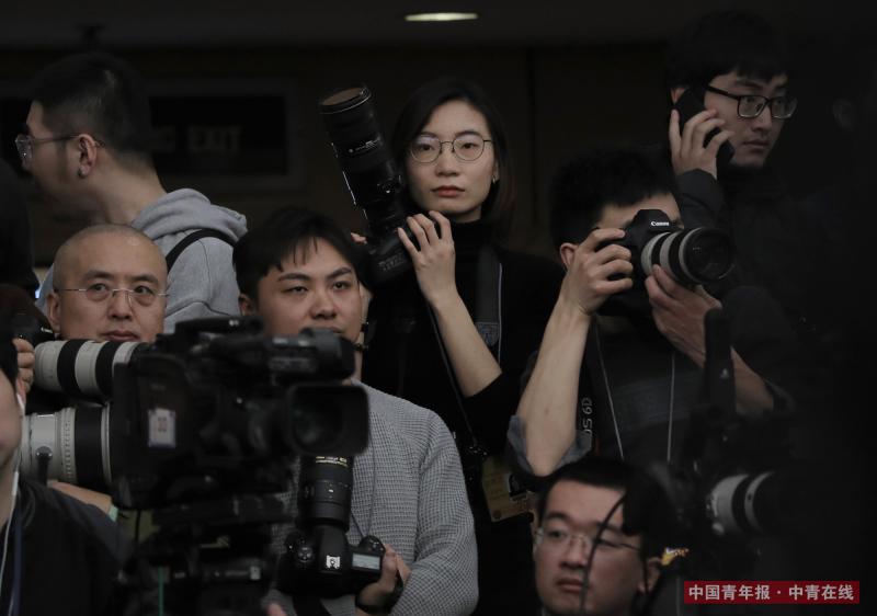 3月8日，十三届全国人大一次会议举行记者会，外交部长王毅即将入场，中国青年报·中青在线记者王婷舒（中）严阵以待。中国青年报·中青在线记者 赵青/摄