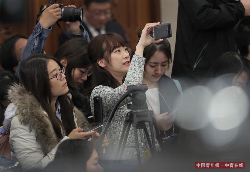 3月4日上午，中国青年报·中青在线记者用手机直播十三届全国人大一次会议首场新闻发布会。中国青年报·中青在线记者 赵青/摄