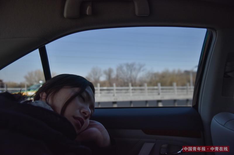 3月8日，连日高强度的工作，让刚刚结束采访的中国青年报·中青在线记者陈婧在车上就睡着了。中国青年报·中青在线记者 王婷舒/摄