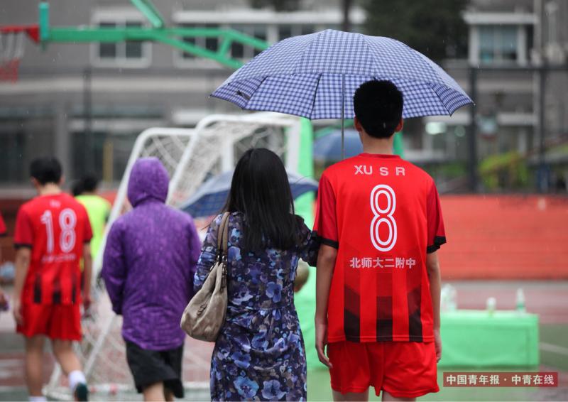 5月19日，北高杯半决赛后，一名家长为球员撑伞离场。实习生 康书源/摄 （编辑：王婷舒）