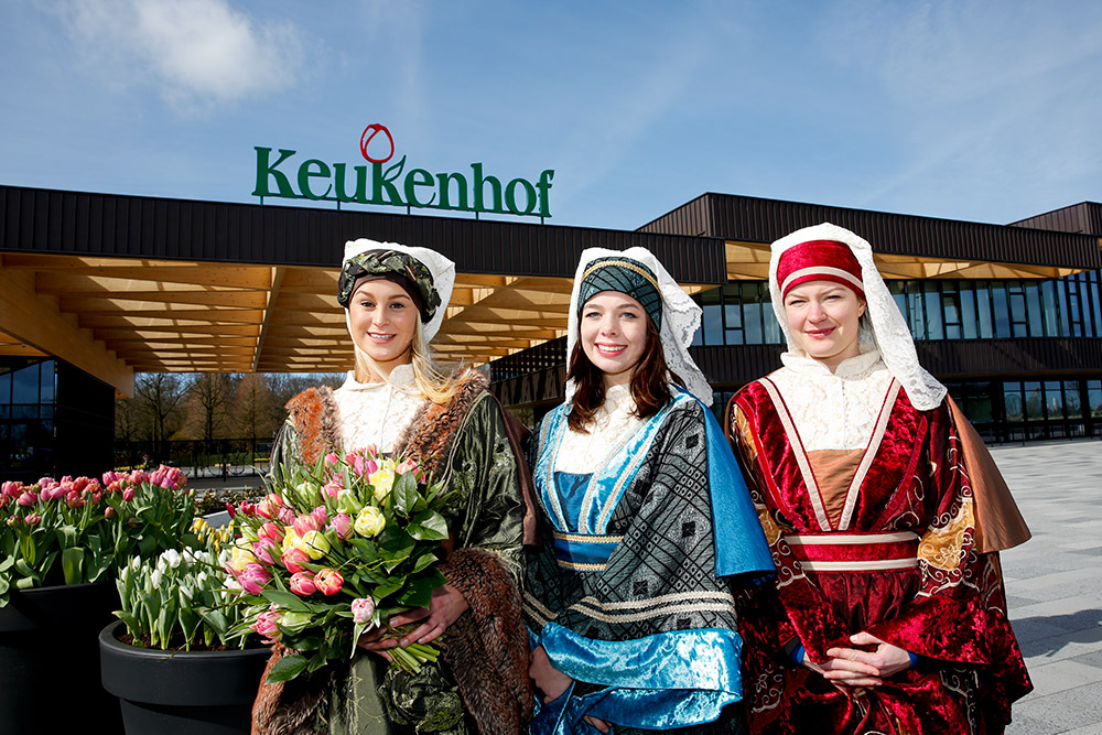 3月21日,在荷兰利瑟的库肯霍夫公园入口,身着传统服装的人们欢迎宾客.