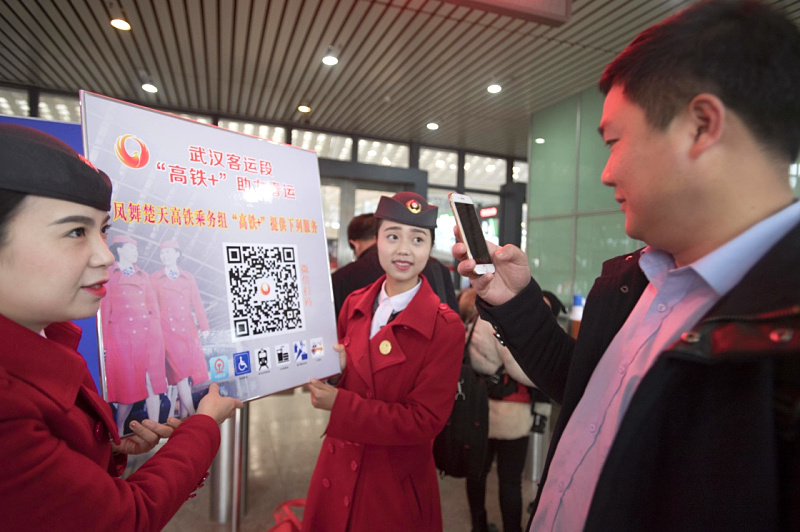 1月11日，一名乘客在武汉火车站扫描“凤舞楚天高铁乘务队”公众号二维码了解服务内容。