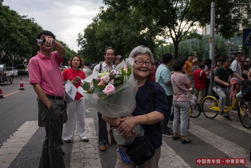 6月8日，北京东直门中学高考考点外，一位年过八旬的老人捧花迎接结束高考的外孙女。下午17时，随着外语科目考试结束铃声的响起，2017年北京地区高考结束。中国青年报·中青在线记者 王婷舒/摄