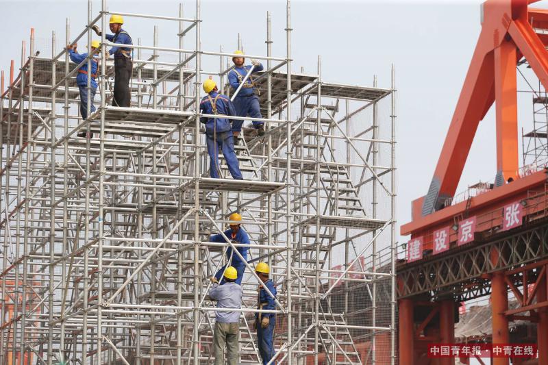 7月20日，中铁大桥局承建的新建京张高铁控制性工程——官厅湖特大桥工地上，工人们搭建高架。据介绍，官厅湖特大桥是世界上第一座适用于设计时速350公里的高寒、大风沙高速铁路的钢桁梁桥。京张高铁全线长约174公里，是助力2022年冬奥会的重点工程，对促进京津冀一体化发展具有重要意义。新建京张高铁计划2019年年底建成通车。中国青年报·中青在线记者 刘占坤/摄