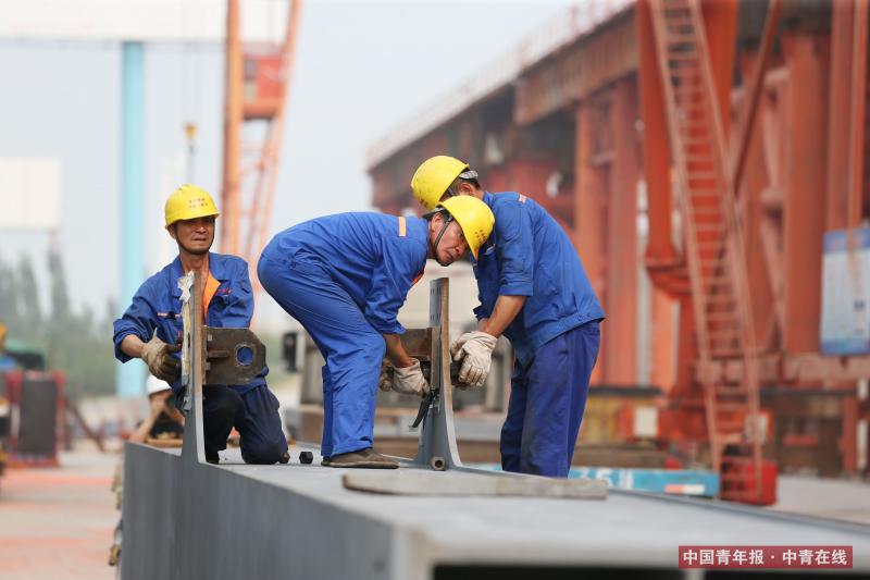 7月20日，工人们准备吊装钢梁。中国青年报·中青在线记者 刘占坤/摄