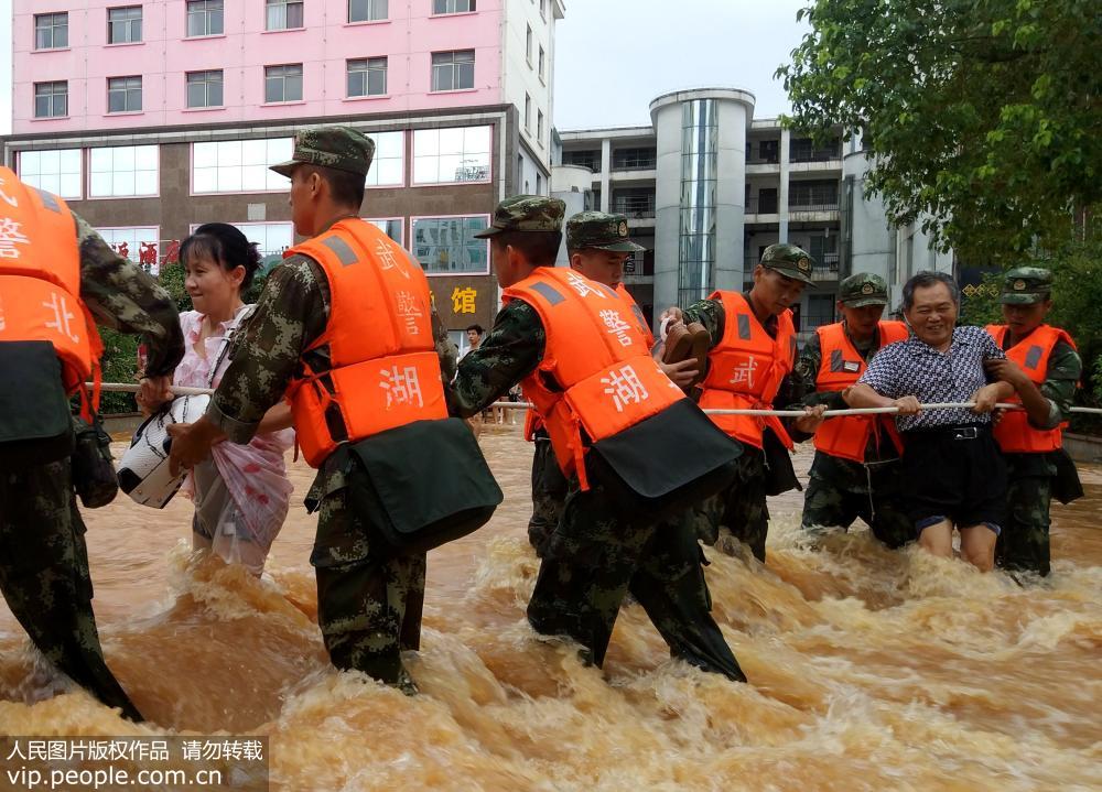 8月13日，武警湖北省总队咸宁支队官兵在咸宁城区转移受灾群众。