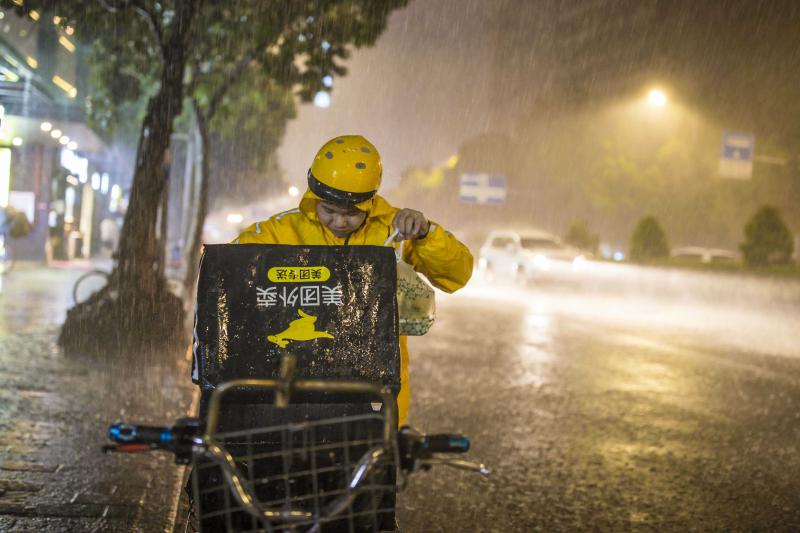 8月22日晚，广州昌岗东路，外卖送餐员在大雨中出行。视觉中国 (编辑：王婷舒）