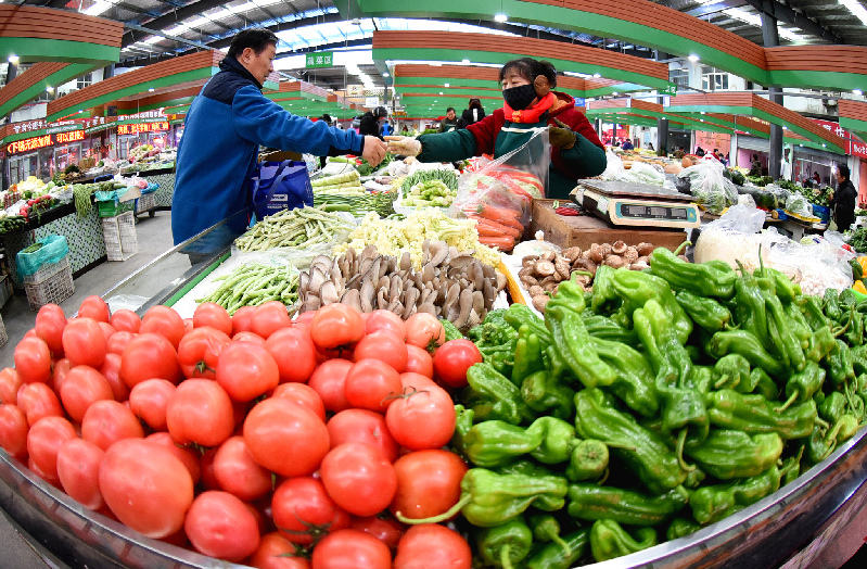 2020年12月9日，居民在江苏连云港市海州区一家农贸市场选购蔬菜。