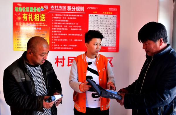 王琪（中）在镇赉县淘宝服务中心为坦途村村民取货（4月11日摄）。新华社记者 林宏 摄
