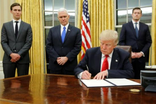 当地时间1月20日，特朗普签署其正式就职后首批行政命令。(图片来源：路透社)