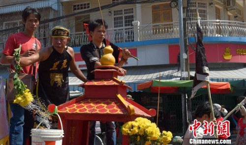 2月11日正月十五是中华民族传统的元宵节，在柬华人舞狮、祭祖，并感恩祭“天地父母”进行“元宵游神”时，也是佛历3月15日柬埔寨王国民众纪念佛祖过“麦加宝蕉节”。在柬华裔吴先生表示，今年“闹元宵”比往年更热闹。图为“游神”在沿街洒“圣水”。