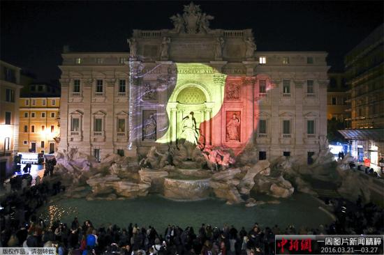 资料图：意大利特莱维喷泉点亮比利时国旗色灯光，悼念布鲁塞尔恐袭遇难者。