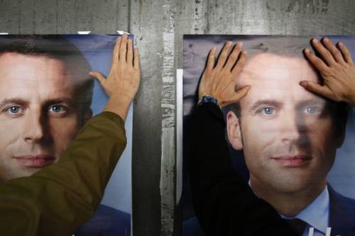 资料图：法国大选期间，马克龙的支持者在张贴竞选海报。