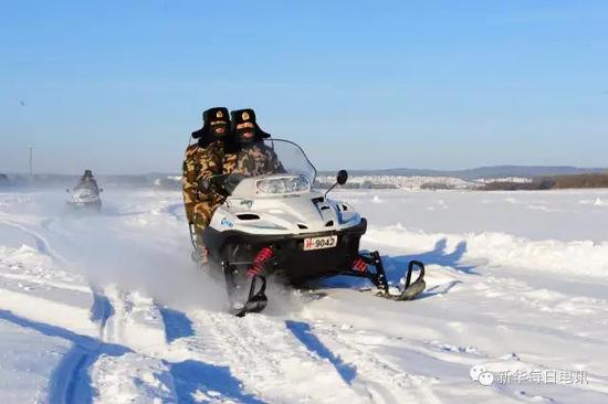 边防民警驾驶雪地摩托巡逻冰封的中俄界江黑龙江。邱小平摄