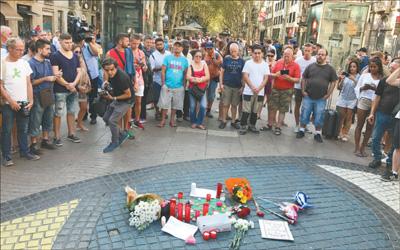 西班牙巴塞罗那恐袭事件后，受害者家属纷纷在兰布拉斯大街举行悼念活动，街上行人自发停下脚步表示哀悼和慰问。本报记者 王 迪摄 