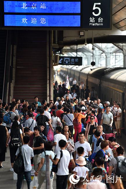 2017年8月21日，旅客抵达北京站。当日起铁路部门迎来暑运返程客流高峰。（人民网记者 翁奇羽 摄）