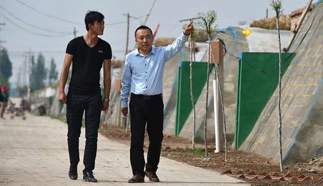 在宁夏中卫市，万立军（右）和员工查看蔬菜大棚（5月21日摄）。新华社记者 李然 摄