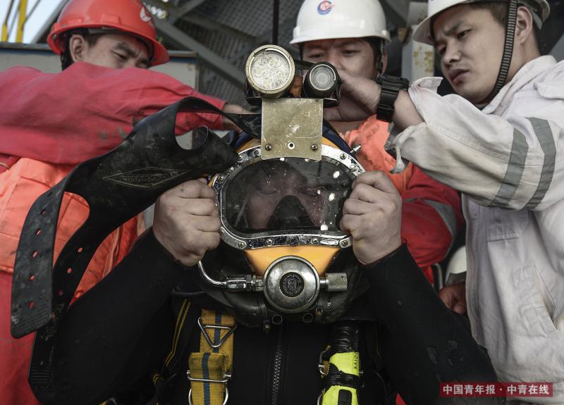 楚金勇需要在几名同事的帮助下穿上重50公斤左右的潜水装备。