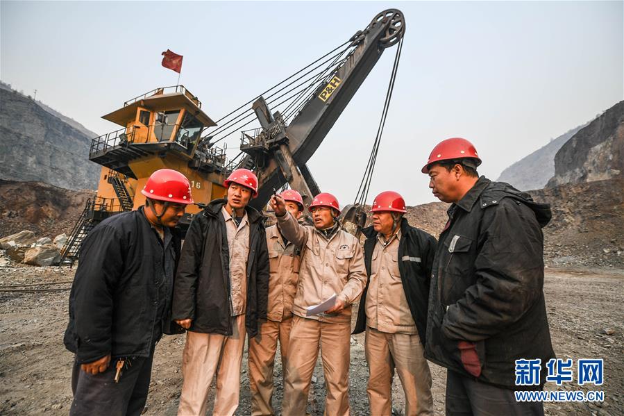 11月3日，郭明义（右三）在鞍钢矿业集团齐大山铁矿采场与工友交流制定修路方案。