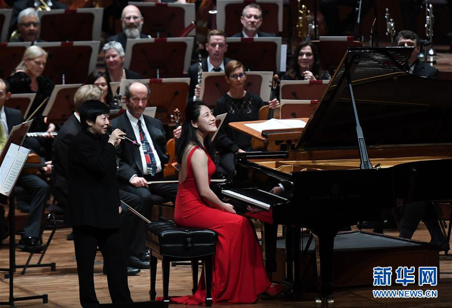2月24日，在美国旧金山戴维斯音乐厅，青年指挥家张弦（前左）向来宾介绍青年钢琴家左章（前右）。 