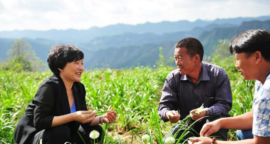 余留芬（左）在岩博村的韭菜地里与村民交流明年的种植计划(10月9日摄) 。新华社记者 陶亮 摄