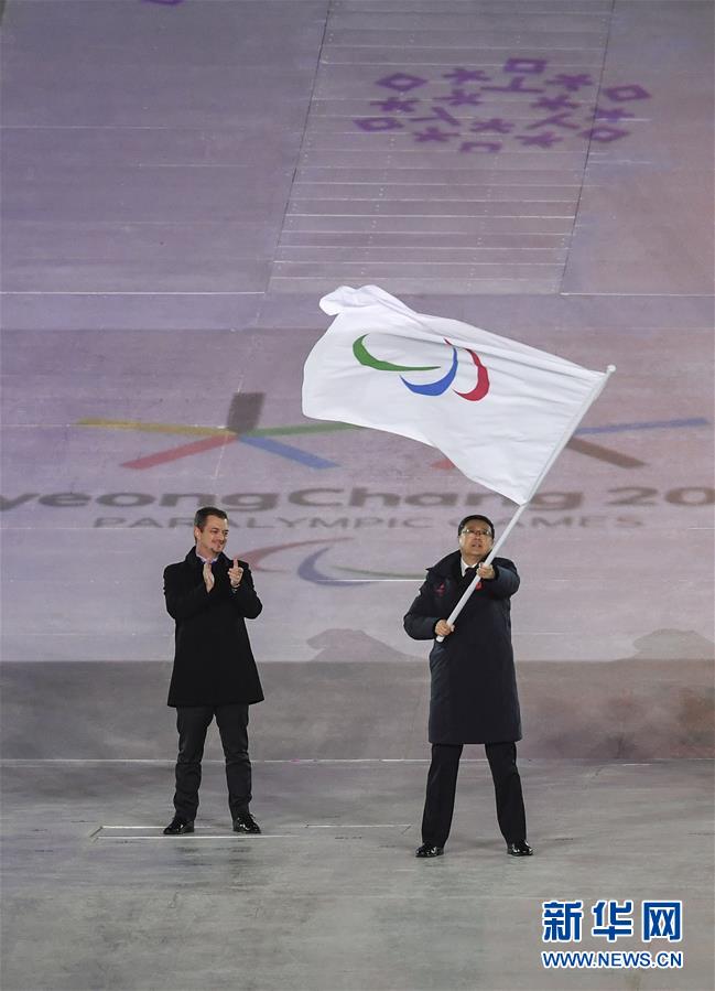3月18日，北京市市长陈吉宁（右）在闭幕式上挥舞国际残奥委会会旗。