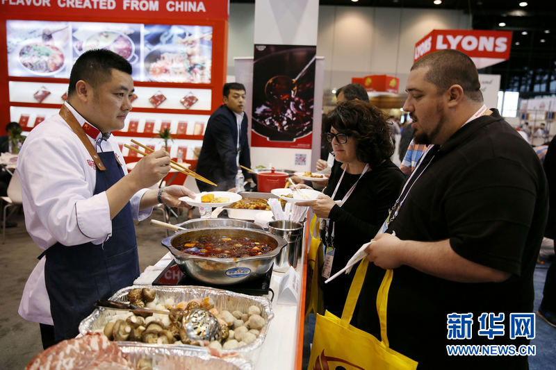 5月19日，在美国芝加哥，美国餐饮展顾客在中国展区品尝中国菜肴。 新华网记者 汪平摄