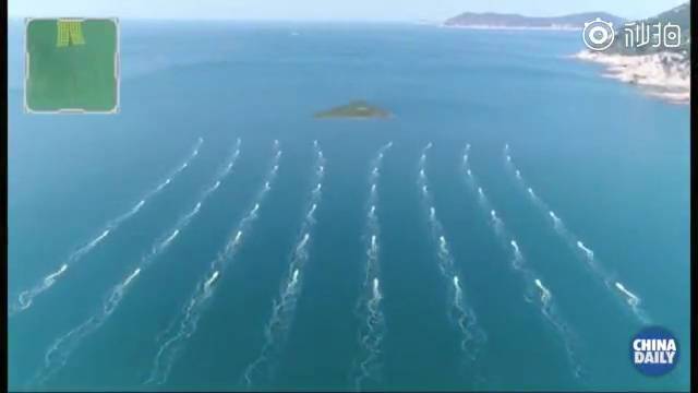 图为56艘无人小艇组成的海上编队整齐划一地前行。（来源：中国日报视频截图）