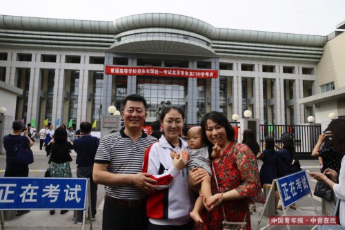 6月8日，北京东直门中学高考考点外，来自北京171中学的考生牛诗翔和家人合影留念。她和妈妈一起抱着的小男孩儿是她弟弟，还不到1岁。