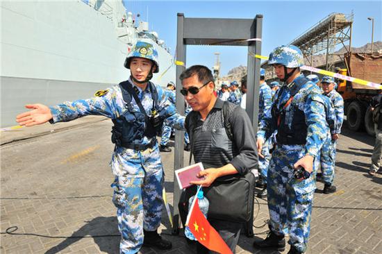 中国海军第十九批护航编队临沂舰抵达也门亚丁港，帮助准备撤离的中国同胞进行安全检查（2015年3月29日摄）。新华社发（熊利兵 摄）